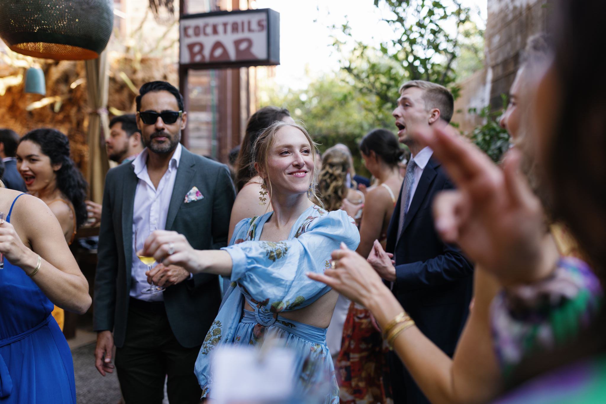 Wedding guests holding cocktails and mingling during the outdoor reception.