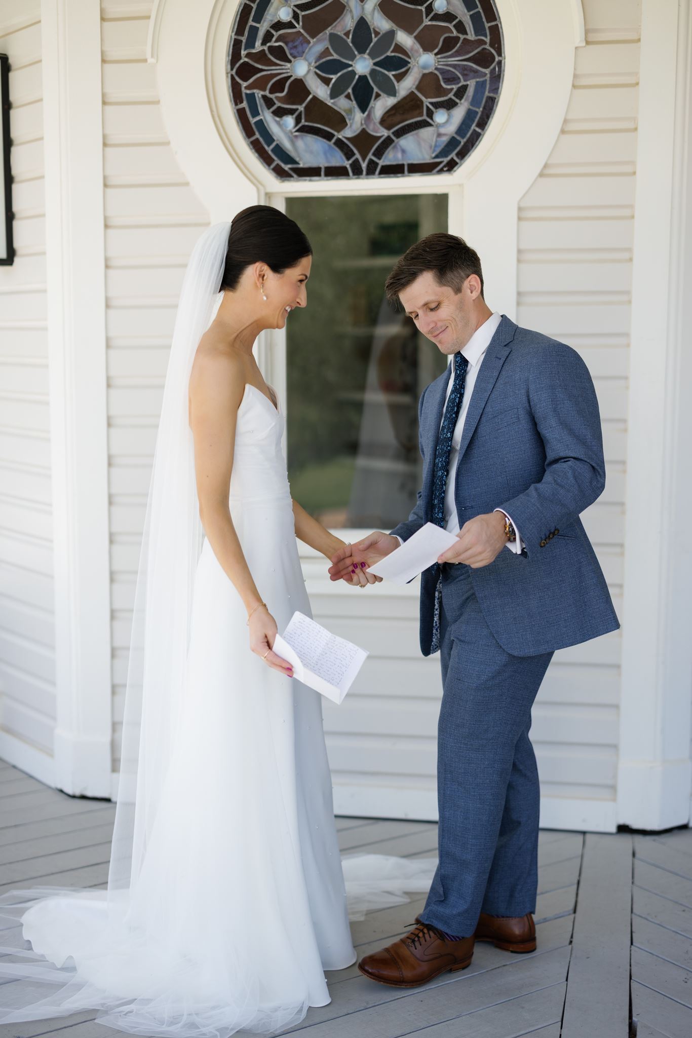 Bride and groom holding hands while they read their private vows