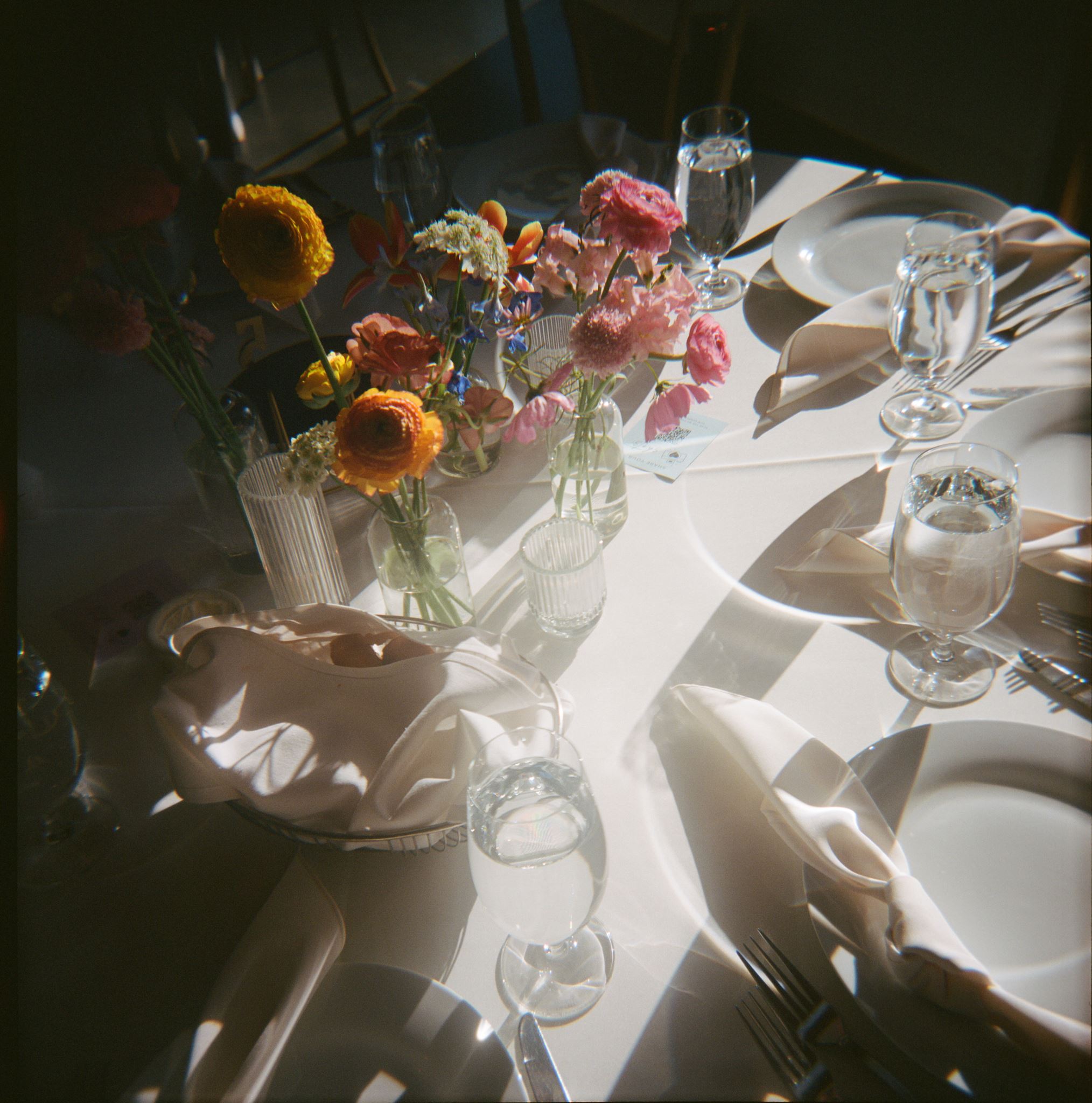 Bird's-eye view of a wedding table decorated with bright yellow and pink florals